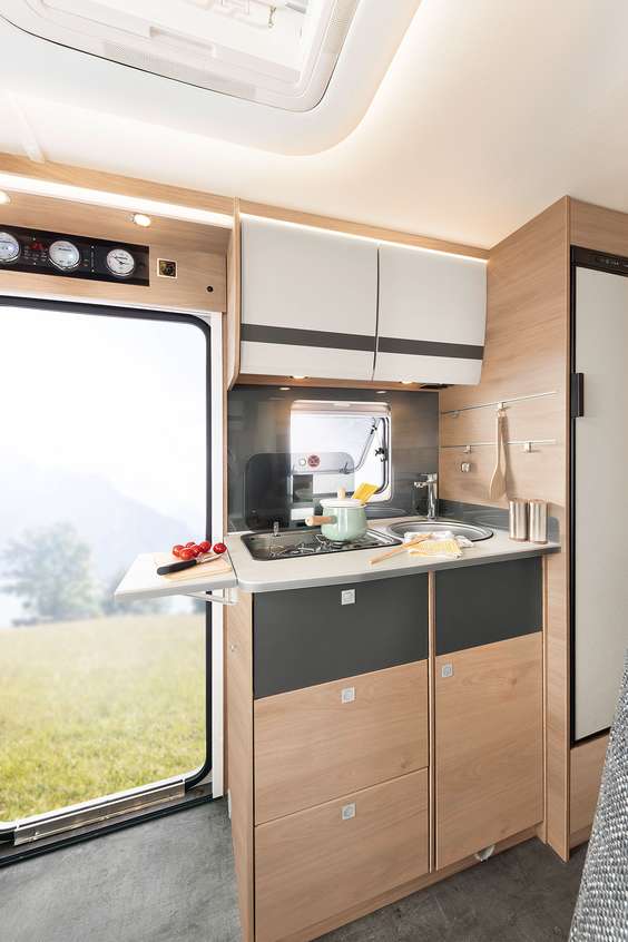 Compact, maar toch alles beschikbaar: volledig uitgeruste keuken met warmwater- voorziening, gasfornuis, grote laden en koelkast • I 6