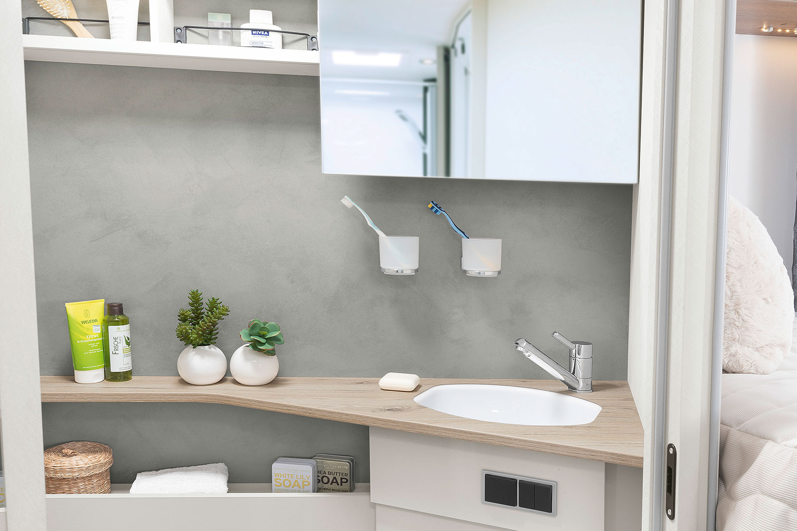 Lichte, moderne toiletruimte met een praktische spiegel die naar opzij kan worden geschoven en veel legplanken en opbergmoge- lijkheden • T 6757 DBL